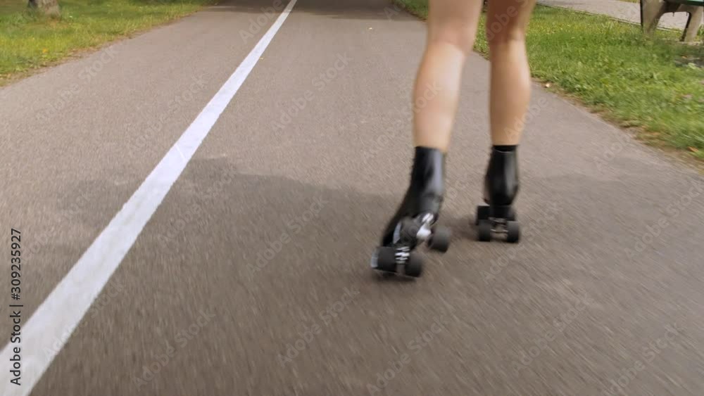 Female legs in roller blades skating. Young Beautiful Girl Roller skating In A Park. Young Woman Rollerblading On A Beautiful Sunny Summer Day In A Park. Female legs in roller blades skating. Young Beautiful Girl Roller skating In A Park. Young Woman Rollerblading On A Beautiful Sunny Summer Day In A Park.