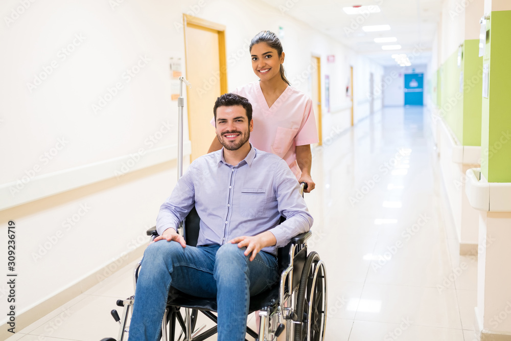Female Healthcare Worker With Patient On Wheelchair At Hospital Female Healthcare Worker With Patient On Wheelchair At Hospital