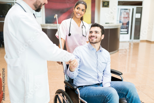 Obraz na plátně Recovered Patient Greeting Goodbye To Medical Team At Hospital