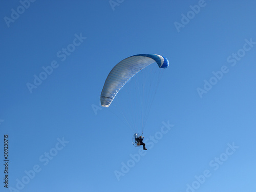 motor paragliding on a sunny day with an intense blue sky