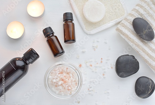 Spa treatment composition, top view, spa and beauty products, pink sea salt, massage stones, essential oils, natural soap.