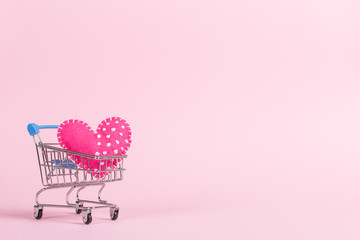 Red heart as a symbol of love, in a shopping trolley, the concept of buying heart for money for Valentine's Day. Commercial promotion, copy space.