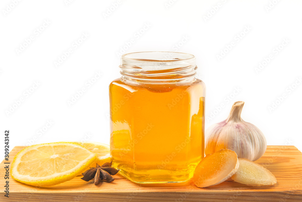 Honey and dipper with ginger, mint and lemon on a white background Honey and dipper with ginger, mint and lemon on a white background