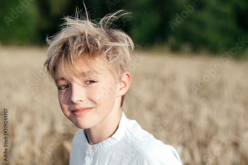 Portrait of smiling boy standing in oat field