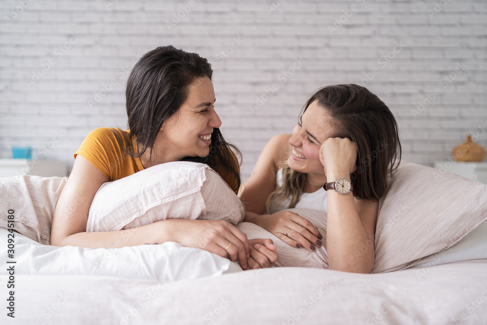 Happy lesbian couple lying in bed Happy lesbian couple lying in bed