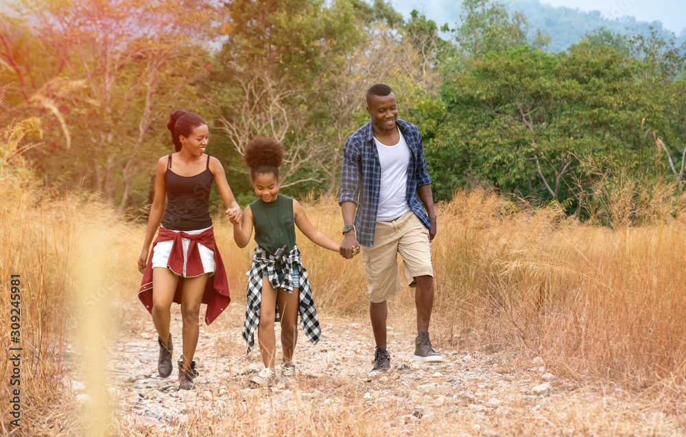 Fototapeta premium Happy mixed race family father, mother and child daughter walking on country road. Travel vacation concept