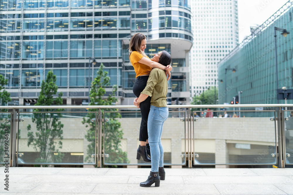 Cheerful lesbian couple in the city, London, UK Cheerful lesbian couple in the city, London, UK