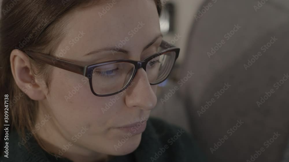 A young woman drinking whilst looking at a laptop computer screen. CLOSE UP. A young woman drinking whilst looking at a laptop computer screen. CLOSE UP.