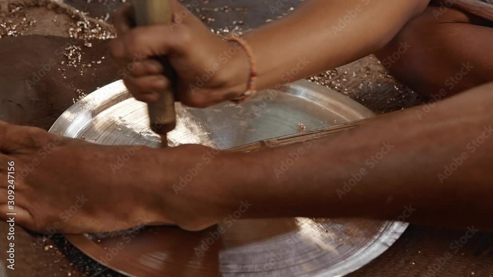 Close up of potter scraping and processing metal material to make a handcrafted metal utensil 