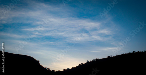 Hills silhouetted against an early evening sky