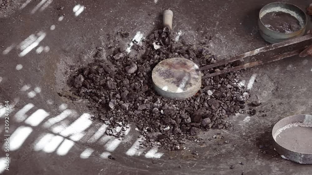 Potter put a metal dish on fire to get hot and ready for shaping. Process of making handcrafted metal utensil Potter put a metal dish on fire to get hot and ready for shaping. Process of making handcrafted metal utensil