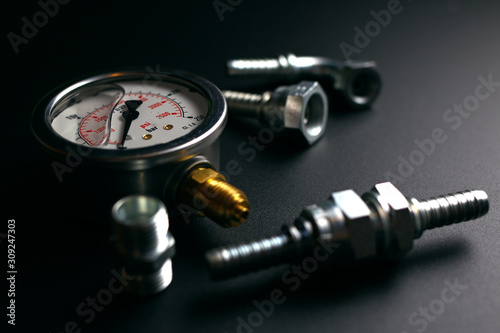 gauge and hydraulic fittings on a black background