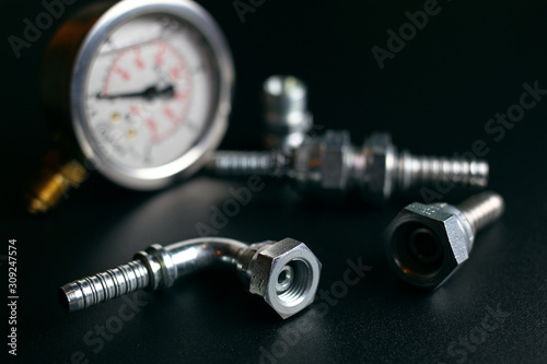 gauge and hydraulic fittings on a black background