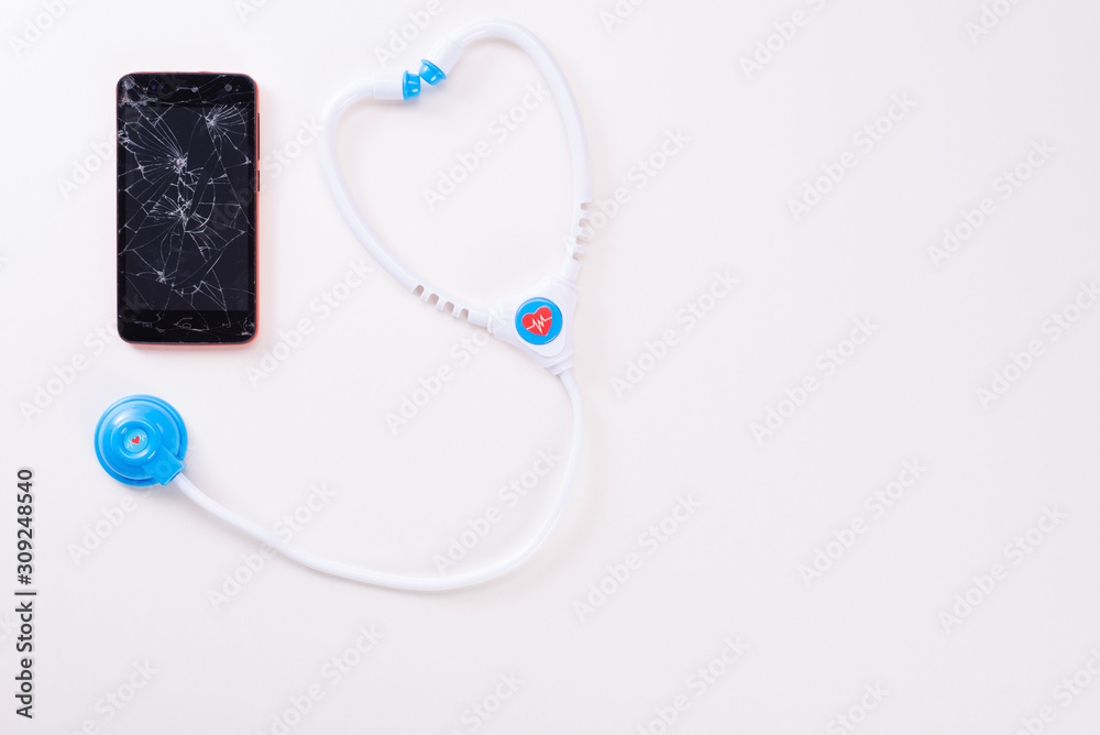 Modern mobile smartphone with a broken screen with a children's fanendoscope isolated on a white background. View from above Modern mobile smartphone with a broken screen with a children's fanendoscope isolated on a white background. View from above