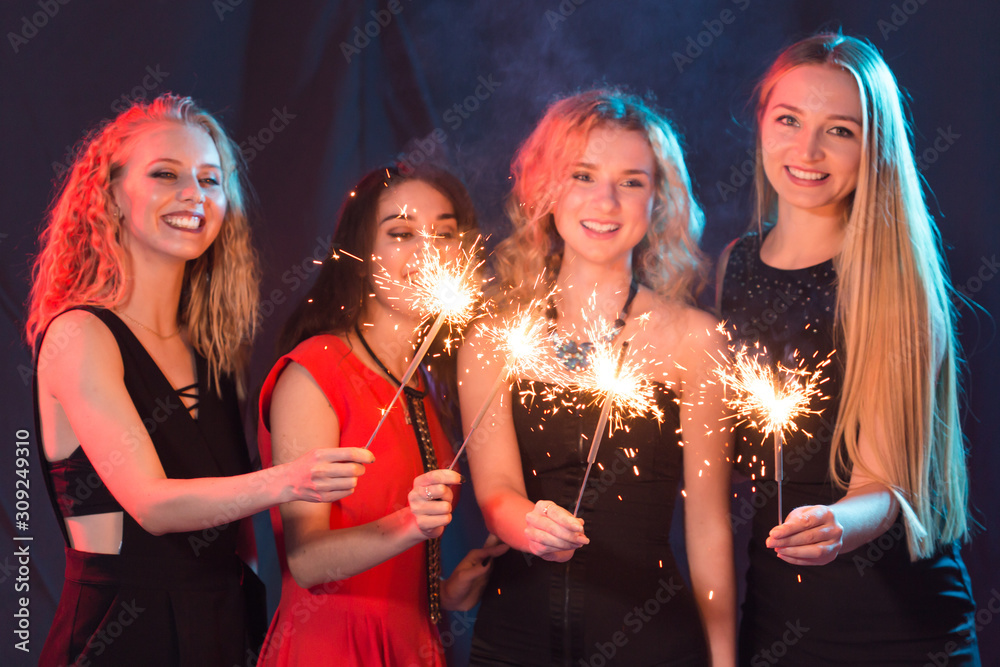 Birthday party, new year and holidays concept - Group of female friends celebrating holding sparklers