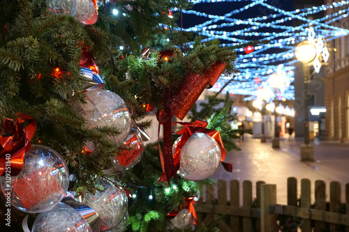 Christmas tree branch on the street at night decorated with balls photo