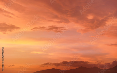 Calm orange and pink sunset sky, silhouettes of mountains below - can be used as background with subjects placed in front © Lubo Ivanko