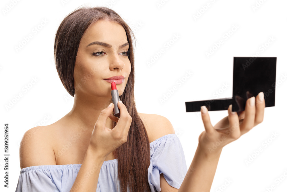 Young beautiful woman applying lipstick and holding a small mirror Young beautiful woman applying lipstick and holding a small mirror