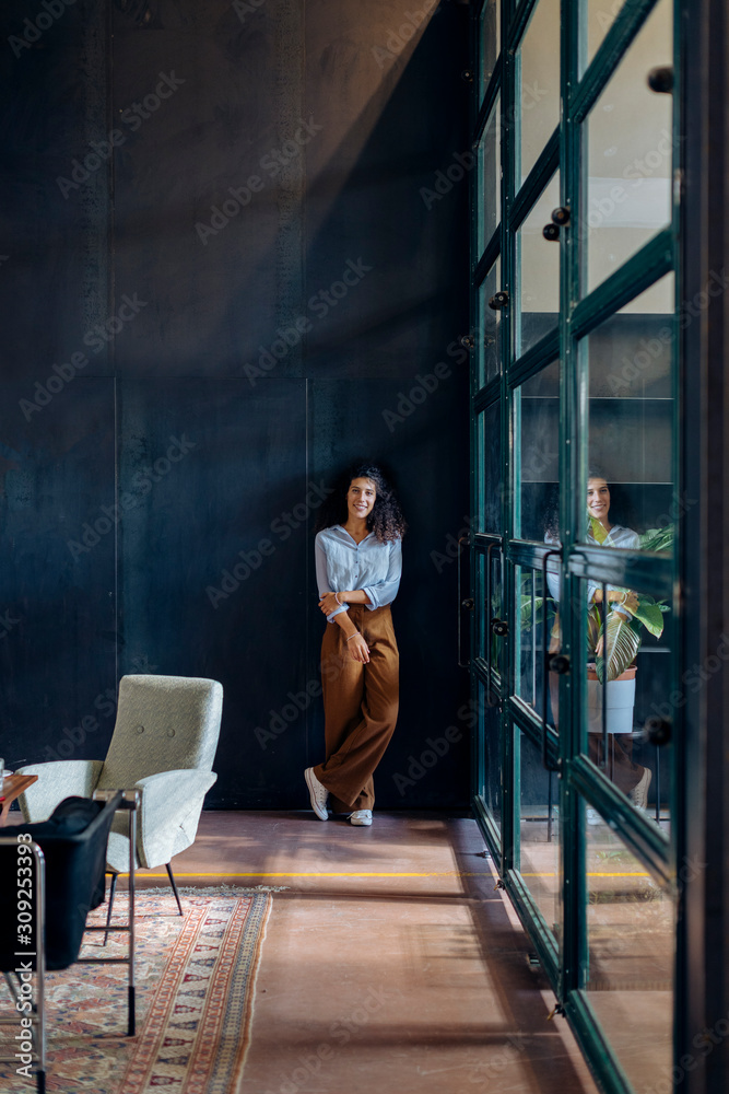 Portrait of young businesswoman standing at the window in loft office Portrait of young businesswoman standing at the window in loft office