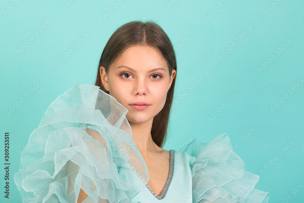 beautiful young woman in a blue dress on a blue background