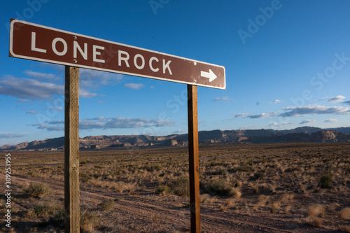 A sign to Lone Rock in an empty desert landscape.