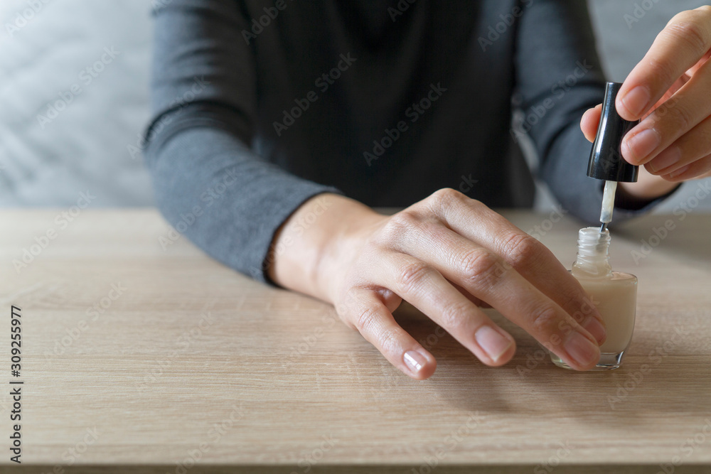 Obraz premium Woman doing the manicure. Removing the polish and putting on the cream. Woman that care his hands. Style concept.