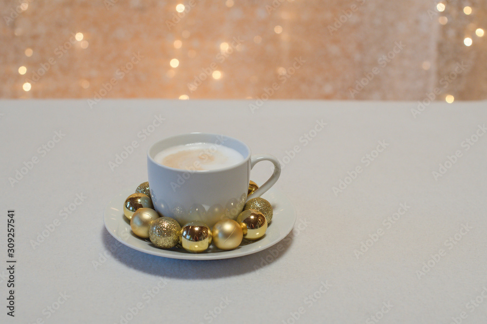 Weihnachtlicher Cappuccino vor Bokeh mit goldenen Mini Christbaumkugeln ...