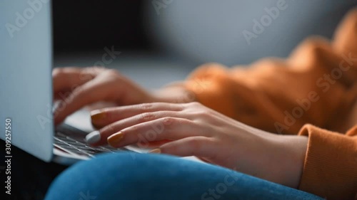 cropped view of teenage girl typing on laptop