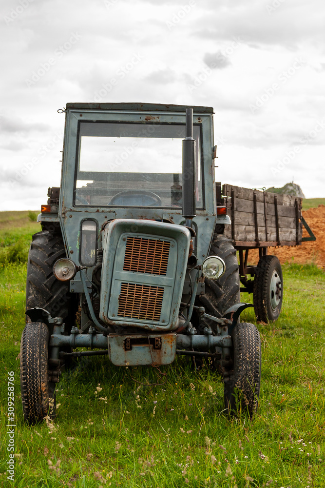 An old and battered tractor in the field An old and battered tractor in the field