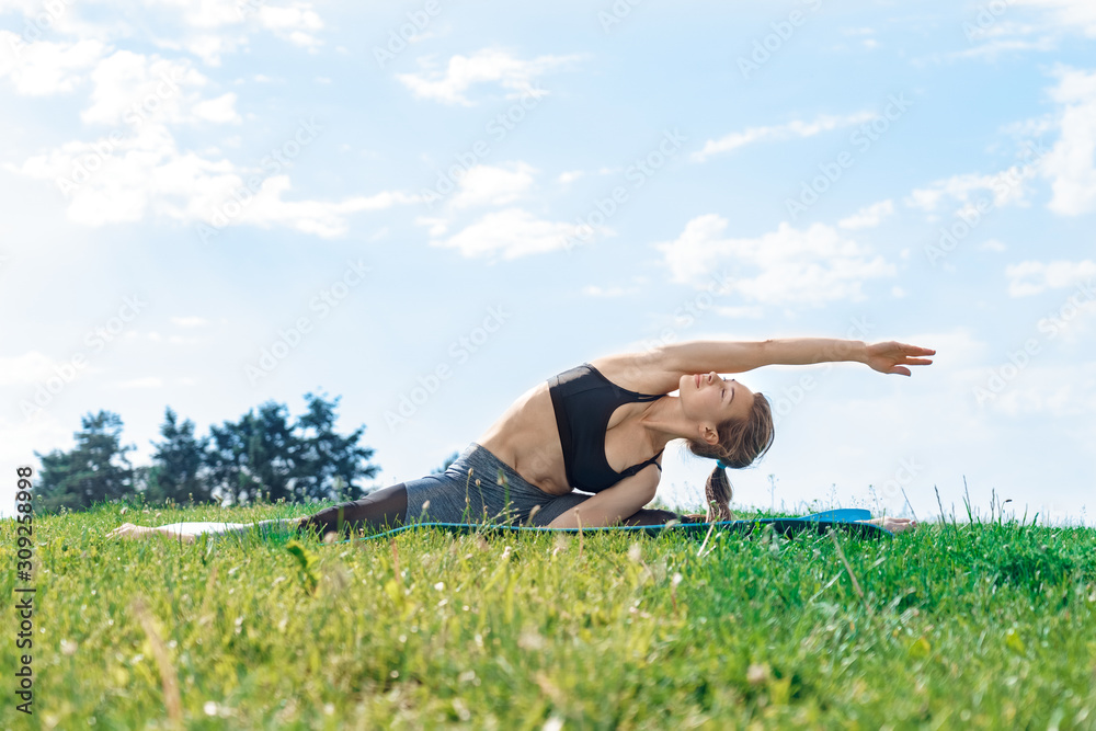Healthy Lifestyle. Young woman outdoors doing yoga split hand aside strecthing closed eyes peaceful Healthy Lifestyle. Young woman outdoors doing yoga split hand aside strecthing closed eyes peaceful