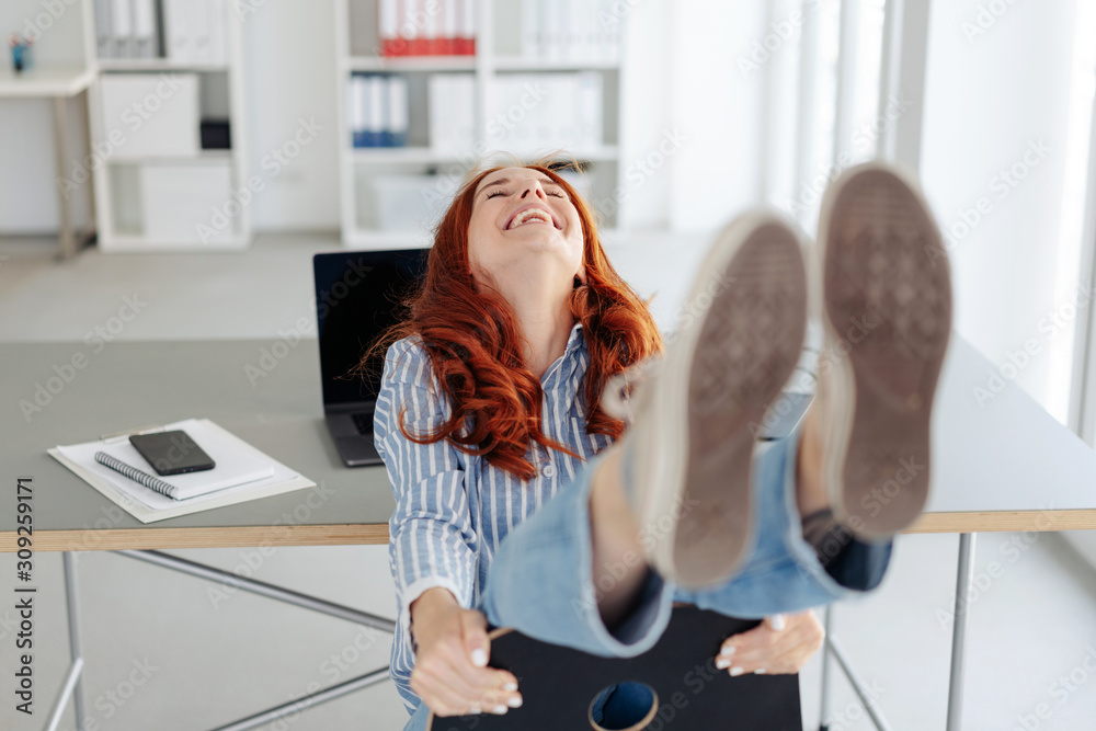 Laughing carefree woman having fun at the office - obrazy, fototapety, plakaty 