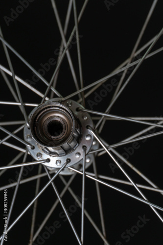  Bicycle repair. Cleaning and replacement of grease in the rear hub of the bike. The rear wheel of the bike on a black background. Spokes and hubs are gray. Modern workshop. Freehub close up