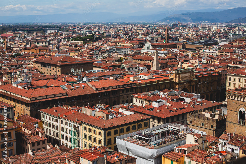 Beautiful super wide-angle aerial view of Florence, Italy with Florence Cathedral di Santa Maria del Fiore, mountains, skyline and scenery beyond the city, seen from the tower of Palazzo Vecchio