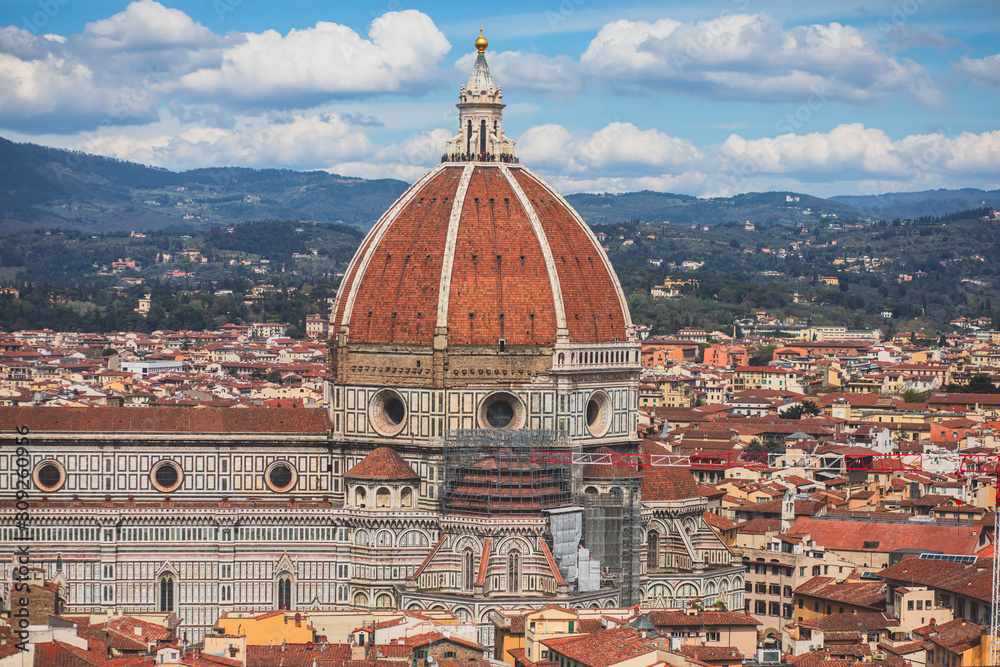 Beautiful super wide-angle aerial view of Florence, Italy with Florence Cathedral di Santa Maria del Fiore, mountains, skyline and scenery beyond the city, seen from the tower of Palazzo Vecchio