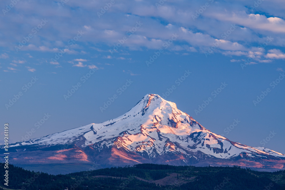 A stunning close up  view of Mount Hood in Oregon, USA during sunset with blue skies