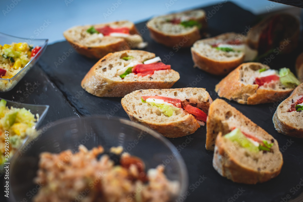 Beautifully decorated catering banquet table with different food snacks and appetizers on christmas birthday party event or wedding celebration, concept of Italian antipasti wine snacks variety set