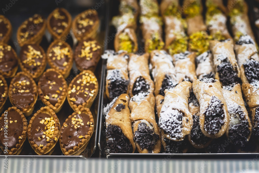 View of different traditional italian pastry candy desserts assorment, with cannoli, panna cotta, tartufo, amaretti, panettone, zeppole bomboloni, semifreddo, cartocci and others in Rome, Italy