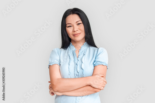 Freestyle. Asian woman standing isolated on white crossed arms smiling confident © Viktoriia