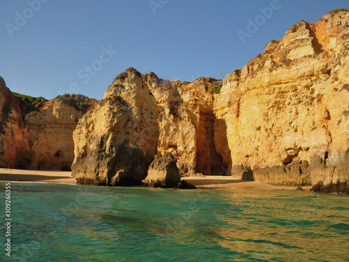 Orange cliffs on the beachfront facing the emerald green sea