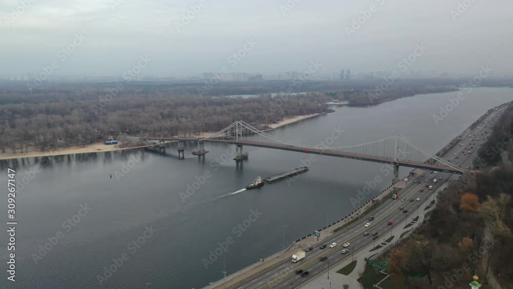 Aerial view of tow boat passing under the bridge.