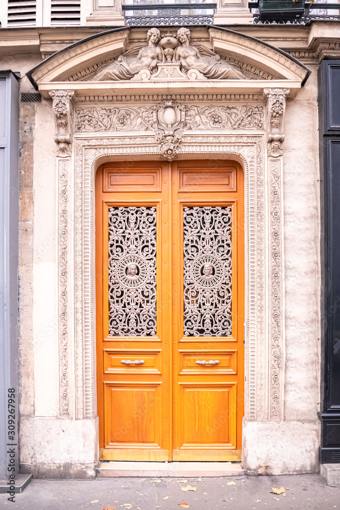Paris, beautiful wooden door, typical building in the Marais, with carved lintel