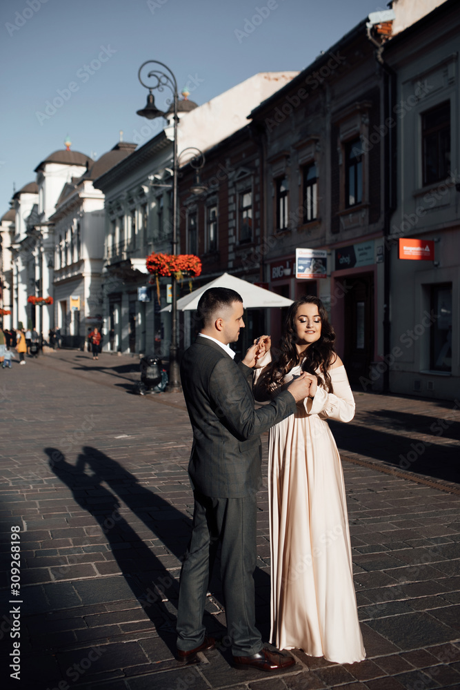 Cute romantic couple having fun outdoors. A love story. Romantic moment. Happy girl in dress and guy posing in suit. Beautiful plus size model in dress outdoors, xxl woman. Happy to be together. 