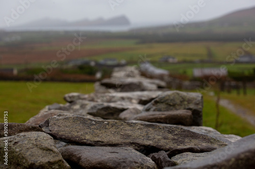 A stone wall on a hill on the DIngle peninsula over looking the sea and the famous three sisters photo