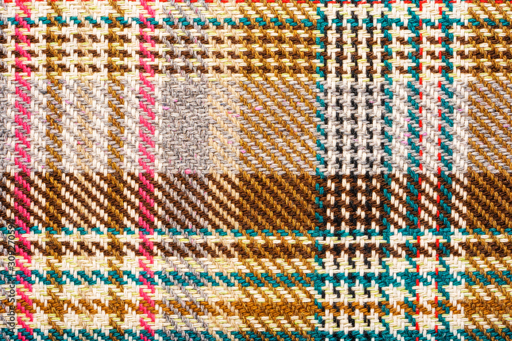 Brown checkered fabric with colored threads. Scottish wool. Fabric for plaid coat and suit. Close-up. Background Brown checkered fabric with colored threads. Scottish wool. Fabric for plaid coat and suit. Close-up. Background