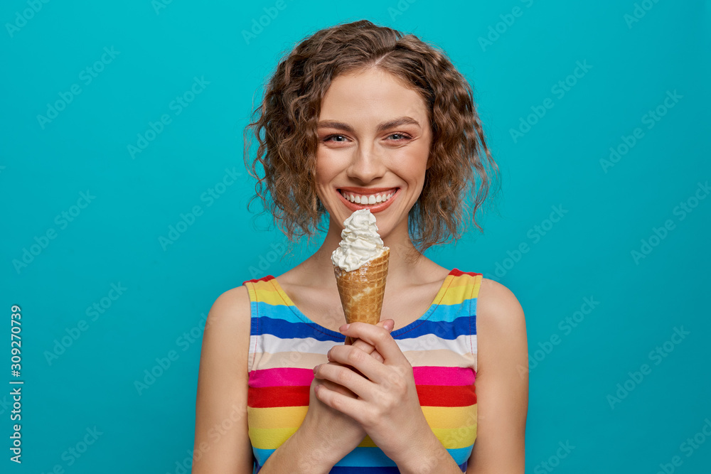 Happy girl in striped dress holding ice cream wafer cone. - obrazy, fototapety, plakaty 