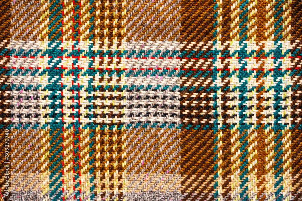 Brown checkered fabric with colored threads. Scottish wool. Fabric for plaid coat and suit. Close-up. Background Brown checkered fabric with colored threads. Scottish wool. Fabric for plaid coat and suit. Close-up. Background