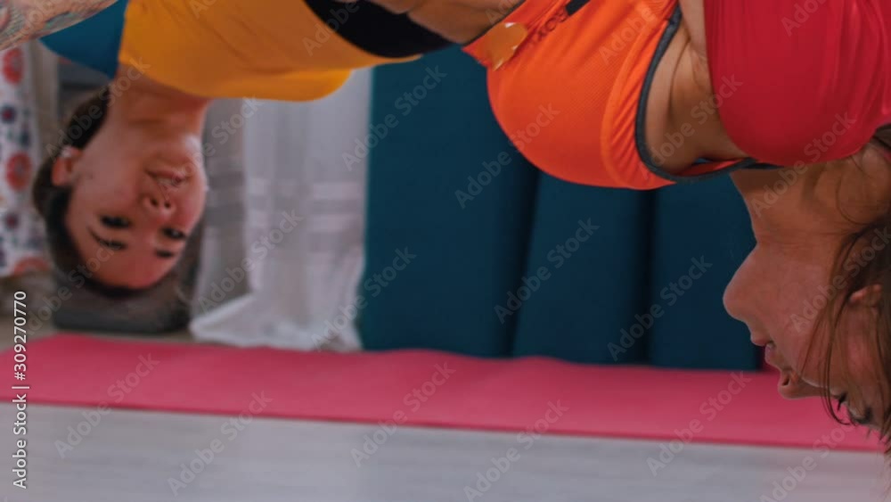Aerial yoga - two women hanging upside down in hammock for yoga Aerial yoga - two women hanging upside down in hammock for yoga