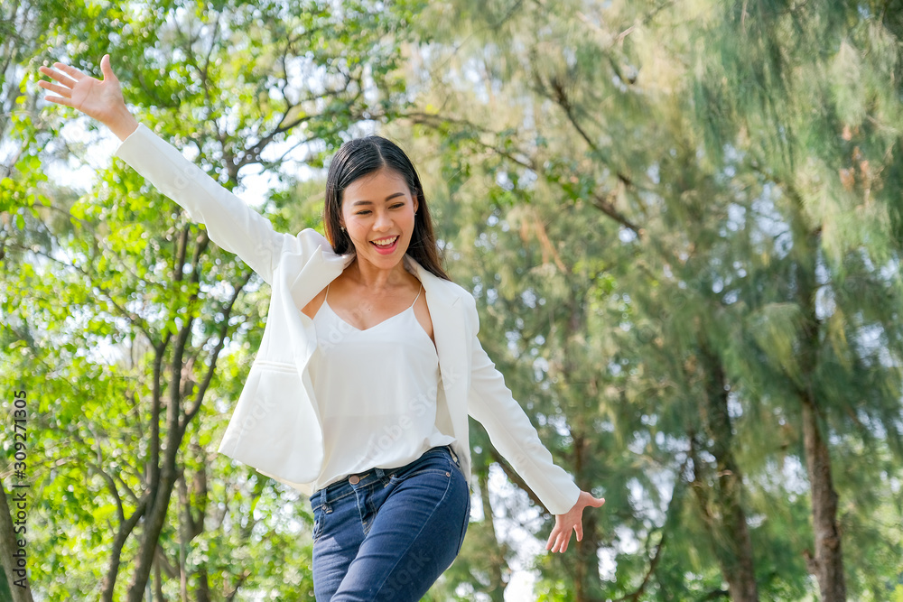 Young Asian beautiful business girl show action of happiness in the garden with day light. Young Asian beautiful business girl show action of happiness in the garden with day light.