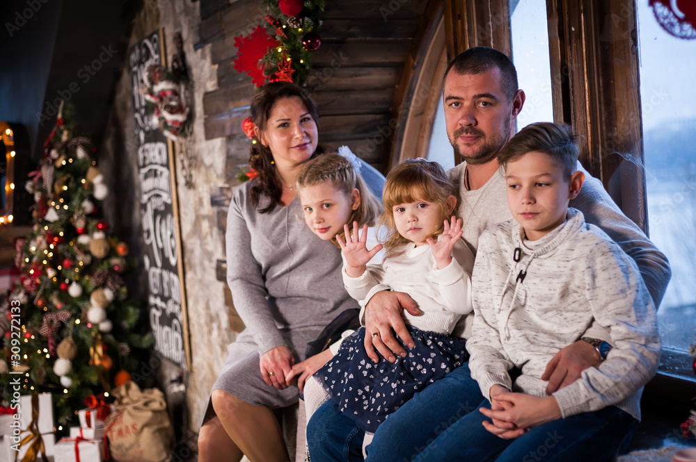 Happy family smiling with gifts in a room at Christmas Happy family smiling with gifts in a room at Christmas
