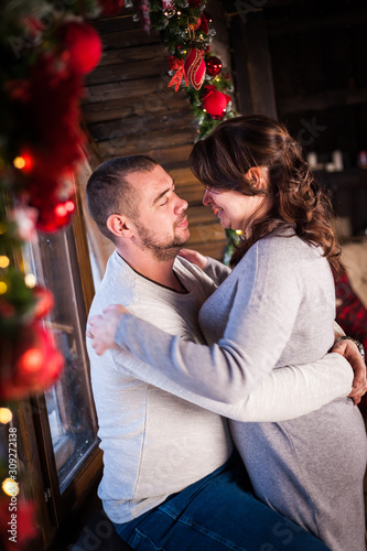 Portrait of a young couple in the living room at Christmas.